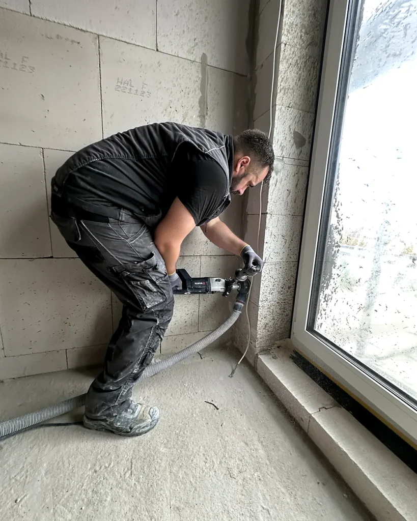 Monteur von Salvus Elektrotechnik bei einer Kernbohrung im Rohbau